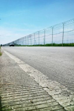 Havaalanının dışındaki yol bir tel örgüyle döşenmiş.