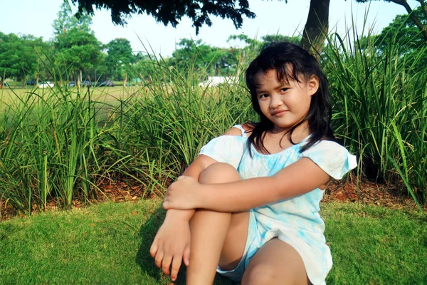 Güzel Asyalı Bir Kızın Gülümseyerek Kameraya Bakışının Portresi Çimlerin Üzerinde — Stok fotoğraf