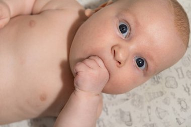 Üç aylık şirin bebek elini yiyor. Diş çıkarma.