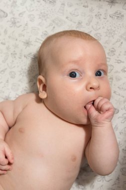 Üç aylık şirin bebek elini yiyor. Diş çıkarma.