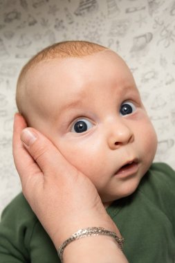 Anne bebeğin yüzüne hafifçe dokunur.