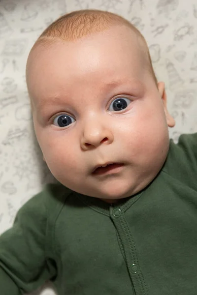 緑の服を着た青い目をした3ヶ月の赤ん坊のクローズアップ肖像画 — ストック写真