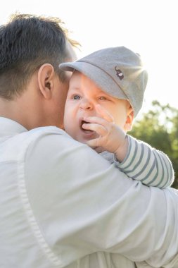 Bebek babasının omzunda ağlıyor.