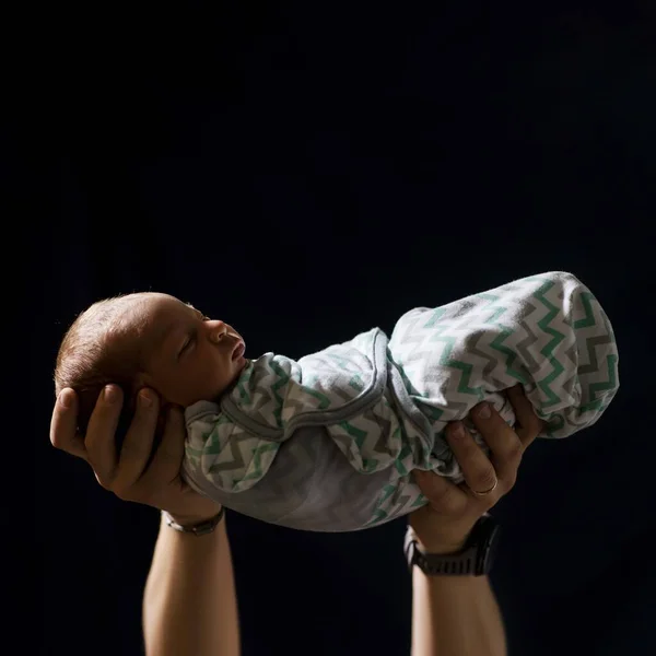 Newborn Baby Arms Dad Black Background — стоковое фото