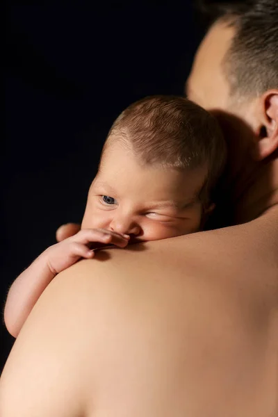 Newborn Baby Arms Dad Black Background — стоковое фото