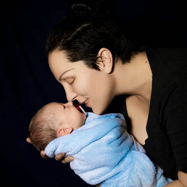 newborn baby with mom on black background