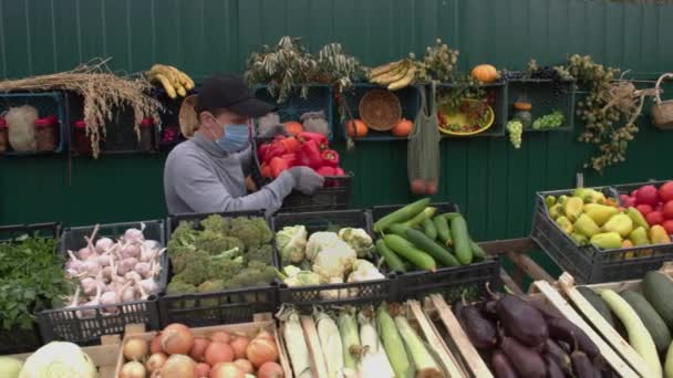 農家の市場で赤ピーマン スローモーション2X 男性の営業担当者は カウンターに赤唐辛子の箱を置き カメラを見て カメラは 野菜の様々なボックスに沿ってスムーズに移動します — ストック動画