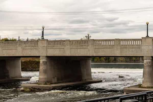 Cambridge, Ontario, Kanada 'daki Grand River üzerinde sokak lambaları olan beton köprü. Arka planda Weir.