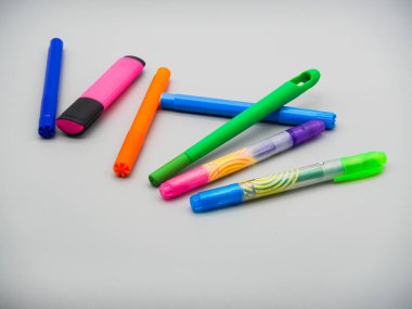 Masada renkli kalemler, keçeli kalemler ve kalemler var.