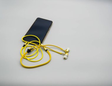 Siyah ekran ve sarı kulaklıklı cep telefonu.