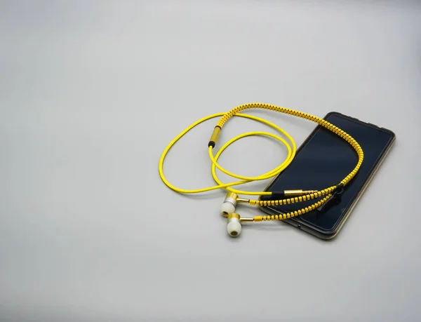 Telefon Komórkowy Czarnym Ekranem Żółtymi Słuchawkami — Zdjęcie stockowe
