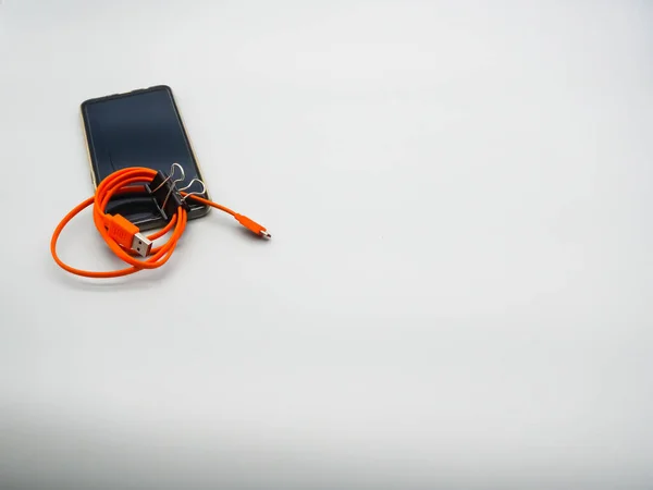 Mobile Phone Dark Screen Bright Orange Charging Cable — Stock Photo, Image