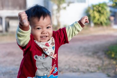 Portrait of a happy little boy 1-year-old living and playing at home in winter with a general cartoon red T-shirt. Happy baby toddler face smiling and looking at camera or mother. Happy face concept.