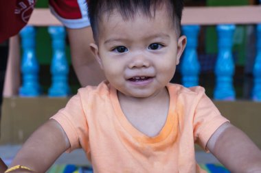 Küçük çocuk evde kız kardeşi ya da annesiyle bisiklet sürmeyi öğreniyor. Asyalı anne oğluna bebek denge bisikleti oynamayı öğretiyor. Güzel genç bir kadın, sevimli oğluna bisiklet sürmesinde yardım ediyor. Aile kavramı