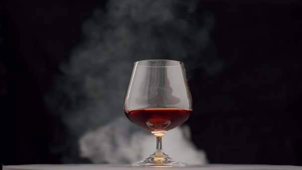 Sterke alcoholische drank Whiskey, Brandy, Cognac in glas met rook van sigaar — Stockvideo