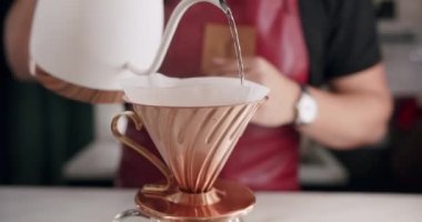 V60 'ın işleyişi, Barista iş yerinde bir fincan koyu kahveyi kağıt filtreye çevirir. 