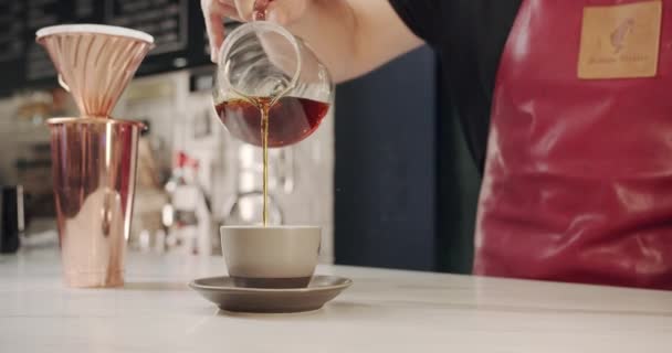 Barista en el trabajo, haciendo y vertiendo café en una taza, en un café moderno — Vídeo de stock