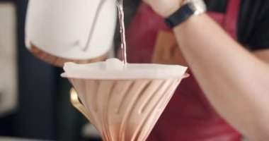 V60 'ın işleyişi, Barista iş yerinde bir fincan koyu kahveyi kağıt filtreye çevirir. 