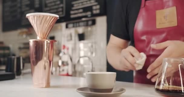 Barista aan het werk, veegt de tafel af na het bereiden van de koffie, reinigt het café — Stockvideo