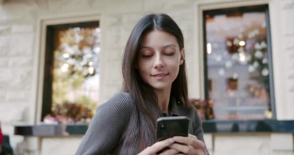 Atrakcyjna brunetka Kobieta korzystająca z telefonu komórkowego na nowoczesnej architekturze, styl życia — Wideo stockowe