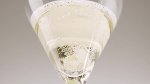 Temiz bir üzüm, beyaz arka plandaki şampanya bardağına düşer. — Stok video