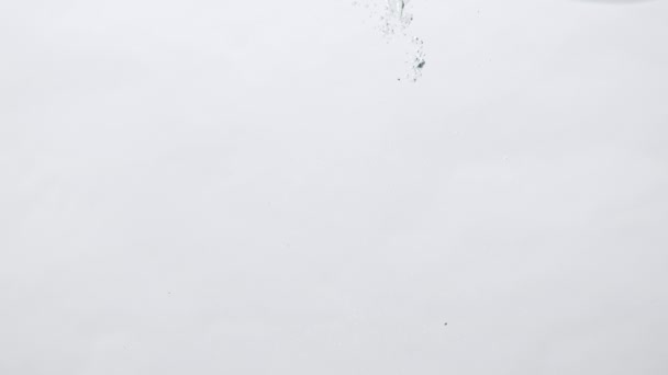 Uva rosata matura con acqua in acquario su fondo bianco, concetto di design — Video Stock