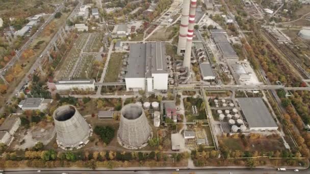 Вид с воздуха на высокие трубы теплоэлектростанции вблизи современного города — стоковое видео