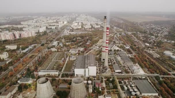 Вид с воздуха на высокие трубы теплоэлектростанции вблизи современного города — стоковое видео