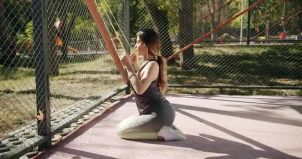 Sportliche Frau macht draußen Übungen mit Widerstandsband — Stockvideo