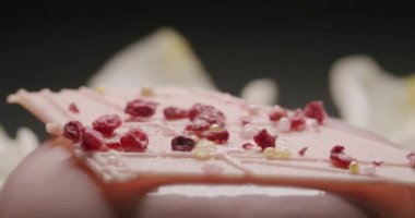 Lezzetli, yuvarlak tatlı ve siyah arka planda pembe krema.