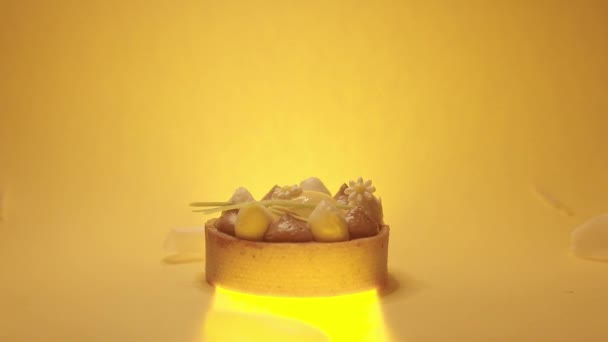 Kieliszek słodkiego okrągłego deseru z białym, brązowym kremem na żółtym tle — Wideo stockowe