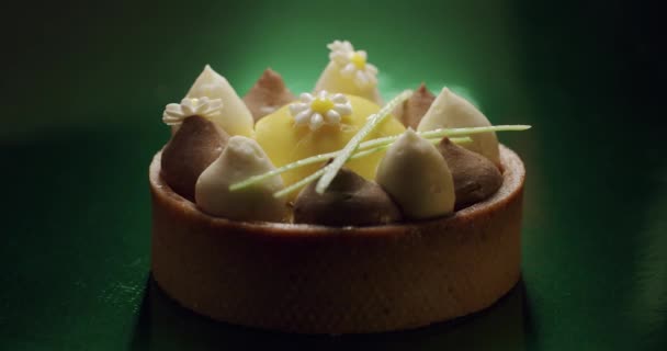 Colpo di dolce dessert rotondo con bianco, crema marrone su sfondo verde — Video Stock