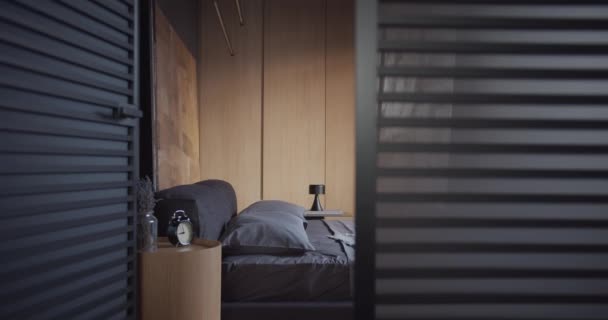 De moderne minimalistische slaapkamer met zwarte en grijze tinten, grote schilderijen en hout — Stockvideo