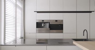 Doğal ahşap yemek alanı olan minimalist bir dairede modern mutfak odası.