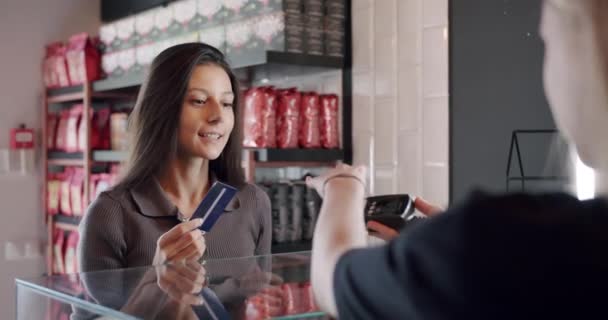 De mooie jongedame betaalt met de kaart in het café, Contactloze betaling — Stockvideo