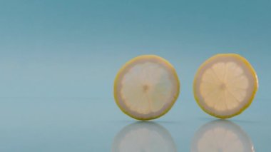 Taze yaz limonlu kokteyli için mavi arka planda çalışan yaratıcı limon dilimleri 