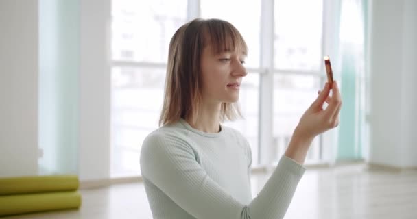 Mujer meditando con Palo Santo, madera santa, relajación zen práctica en estudio — Vídeos de Stock