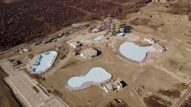 Aquapark im Bau auf einer großen Sandbaustelle mit Spaßbahnen — Stockvideo