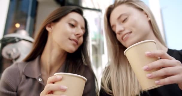 Κοντινό πλάνο, δύο όμορφα κορίτσια ζητωκραυγάζει τσάι ποτά με χάρτινο κύπελλο την καλοκαιρινή μέρα — Αρχείο Βίντεο