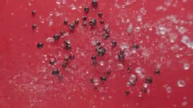 Olgun siyah üzümler kırmızı zemin üzerine suyla düşer, tasarım meyveleri kavramı