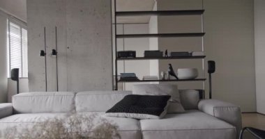 Oturma odası, minimalist mobilya dizaynı ve beton kaplı modern bir daire.