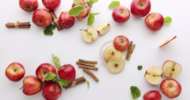 Manzanas rojas naturales con rodajas y hojas, canela, concepto sobre fondo blanco — Vídeo de stock