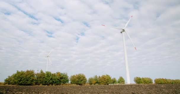 Las turbinas eólicas de los molinos de viento trabajan en un campo de cultivo, central eléctrica — Vídeos de Stock