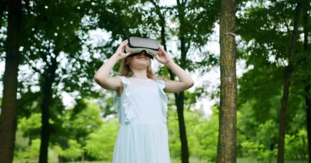 A Teenage Girl wears VR Glasses and play simulation 3D video Game in nature. — Stock Video