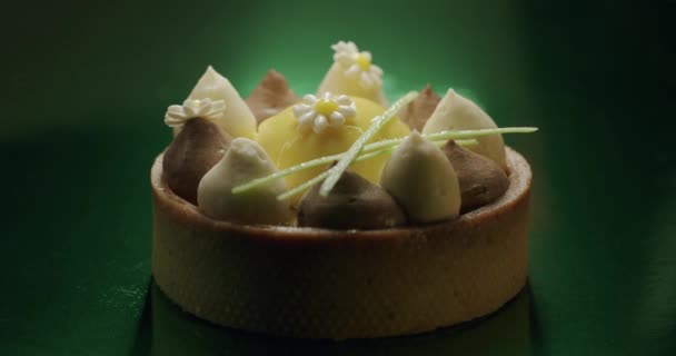 Skott av söt rund dessert med vit, brun grädde på grön bakgrund — Stockvideo