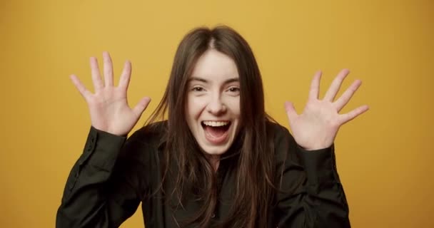 En kvinde gør en følelsesmæssig overraskelse, skjule sine øjne med sine hænder. og Smil – Stock-video
