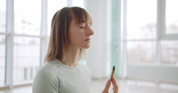 Woman meditating with Palo Santo, holy wood, relaxation zen practice in studio — Stockvideo
