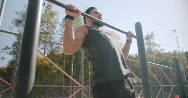 Giovane e muscoloso uomo che fa pull-up su barra orizzontale durante il suo allenamento — Video Stock