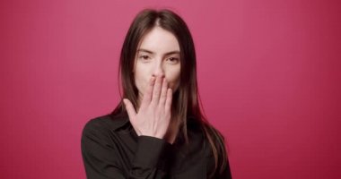 Hoş bir kadın sanal bir öpücük gönderir. Pembe, kırmızı arka plan. Moda, güzellik.