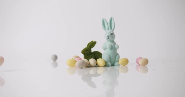 Kanin med vit bakgrund, många färgade ägg. Grattis på påskdagen. Textmeddelande — Stockvideo